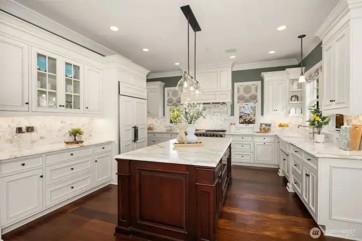 Grand inviting chefs kitchen with a built-in SubZero filled with natural light and abundant counter space.