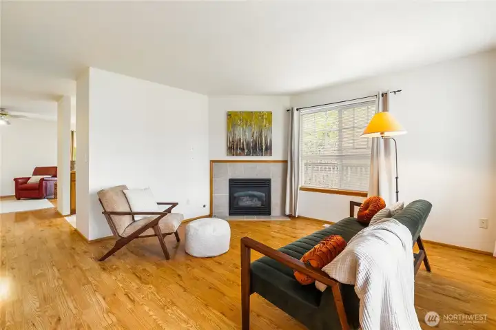 Step inside to a formal living room featuring a gas fireplace for cozy fall and winter evenings, complemented by warm hardwood floors that enhance the space.