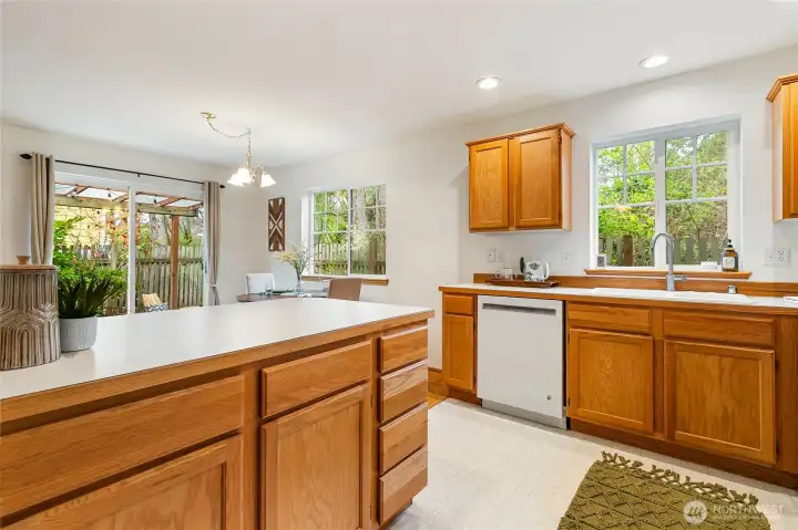 Kitchen view looking towards the dining  area with a small glimpse of the backyard covered patio.
