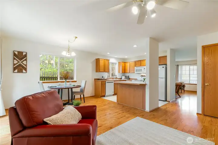 This photo captures a clear view of the homes layout looking from the family room towards the dining, kitchen and formal living room seen in the distance.