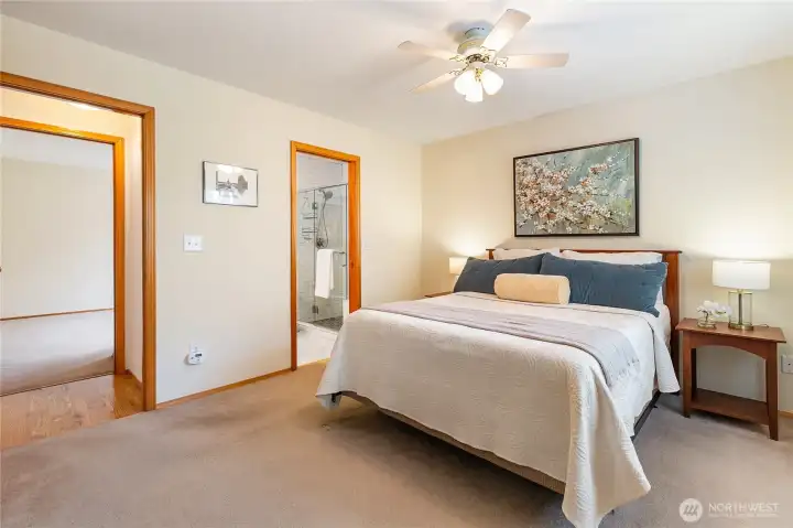 This expansive primary suite features a walk-in closet, a comfortable sitting area, and a beautifully updated bathroom.