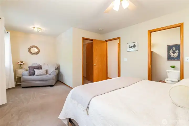 This extra large primary bedroom has enough room for a sitting area. Walk-In closet is behind the wall to the right of chair.