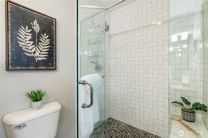 Large walk-in shower with seating area.