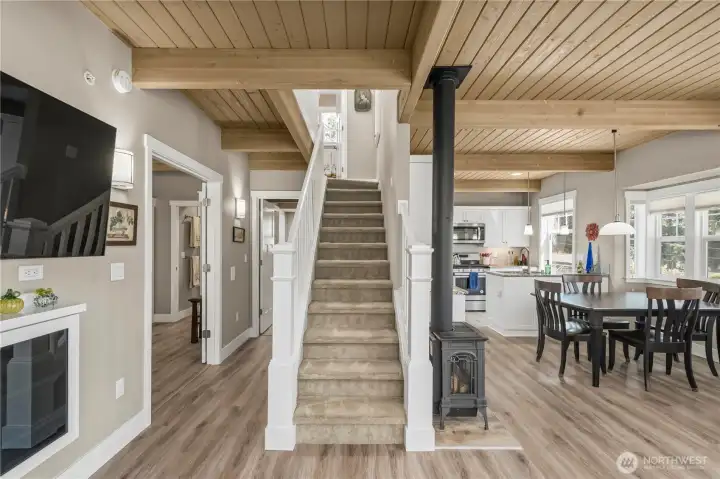 A great view of the great room, staircase and hallway to the main floor bedroom and bath