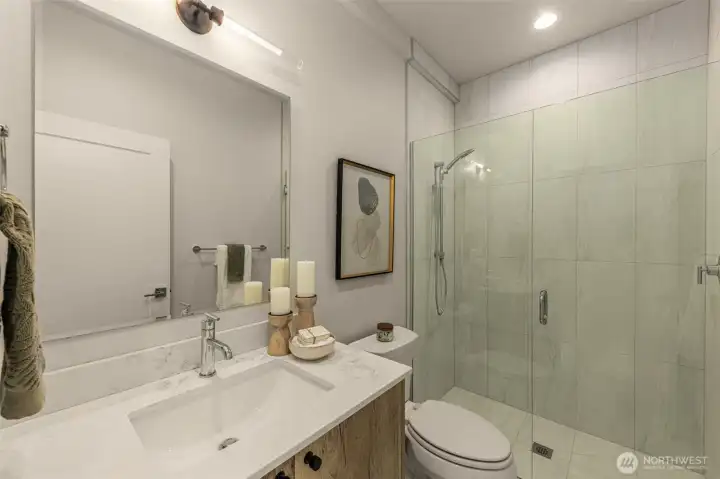 Contemporary bathroom with a frameless glass shower, chic vanity, and carefully curated accents for a luxurious feel.