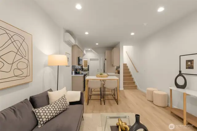The open floor plan view shows off the beautiful flow from the living area to the kitchen, with sleek wood floors and designer finishes. This home is the epitome of functional style.