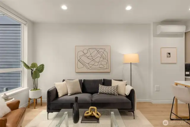 A welcoming seating area with modern decor. The neutral tones and abundant light from the large windows make this living space inviting and relaxing.