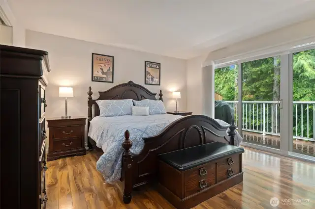 Lovely Primary bedroom has gleaming, engineered hardwood flooring, and private deck access