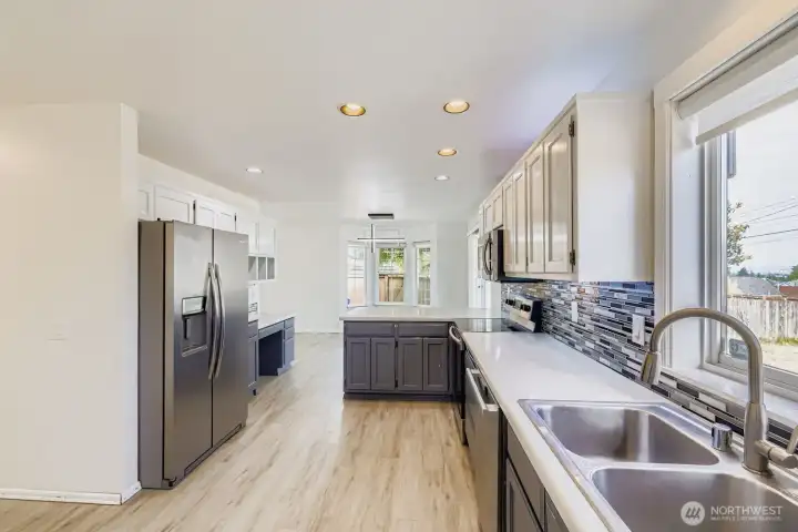 Work, cook, and gather with ease. This kitchen features a built-in desk, generous storage, and sleek stainless steel appliances, including a newer Miele dishwasher