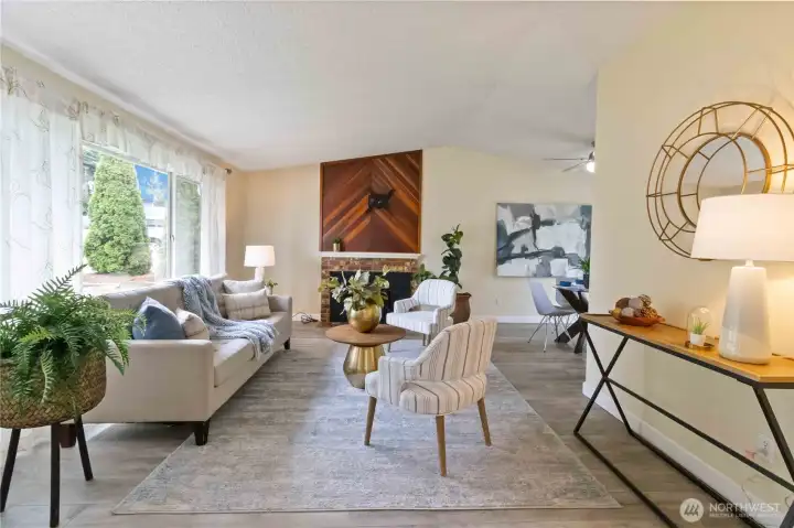 Charming living room with statement wood-accent fireplace and abundant natural light.