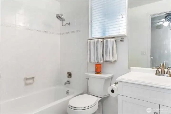 Well-appointed full bath with tub and functional storage vanity.