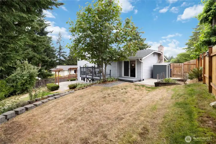 Spacious backyard with mature trees and a fully fenced perimeter.