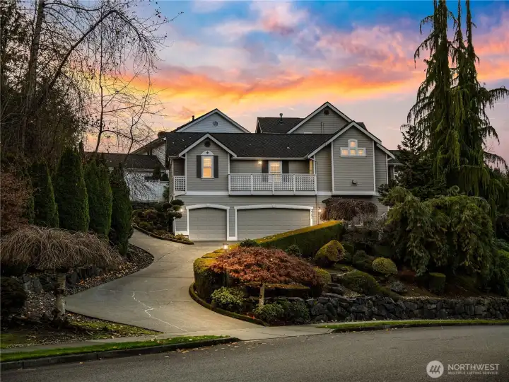 The side of the home offers a spacious three-car garage with a wide driveway