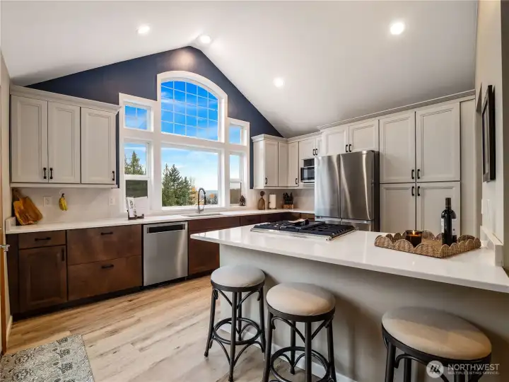 Fully remodeled kitchen featuring new quartz countertops, vaulted ceilings, and all-new cabinetry
