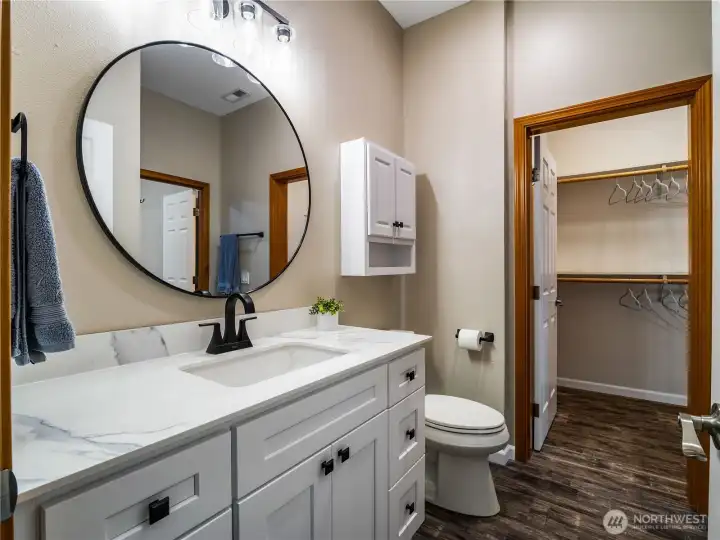 Fully remodeled bathroom featuring a modern vanity, clean, updated finishes, and direct access to the walk-in closet, conveniently located off the downstairs bedroom