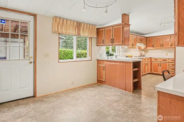 This spacious kitchen layout offers plenty of storage and a perfect breakfast nook by the window