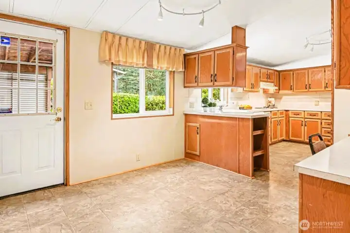 This spacious kitchen layout offers plenty of storage and a perfect breakfast nook by the window