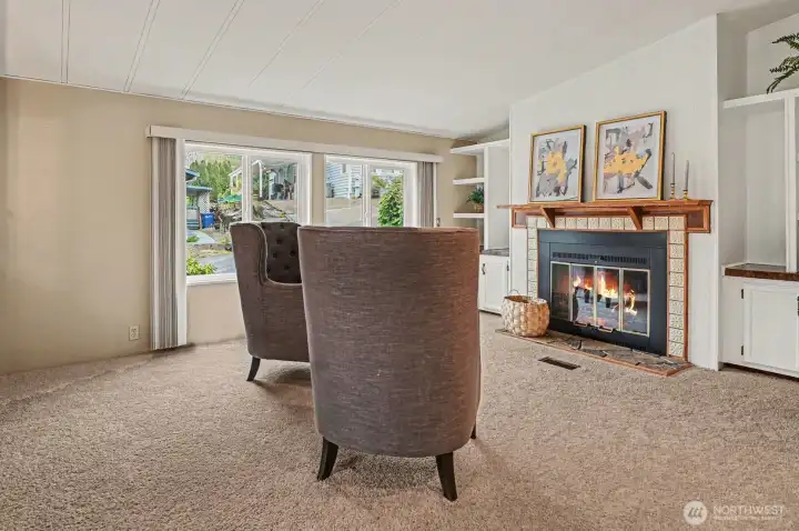 Imagine rainy afternoons spent by this elegant tiled fireplace. Large windows flood the room with natural light, creating a bright and airy sanctuary