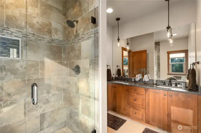 The luxurious walk-in shower features custom tile work.