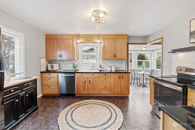 Open kitchen (2024 dishwasher and 2024 oven/stove). Kitchen is off the entry and leads to the breakfast nook, side patio and dining room.