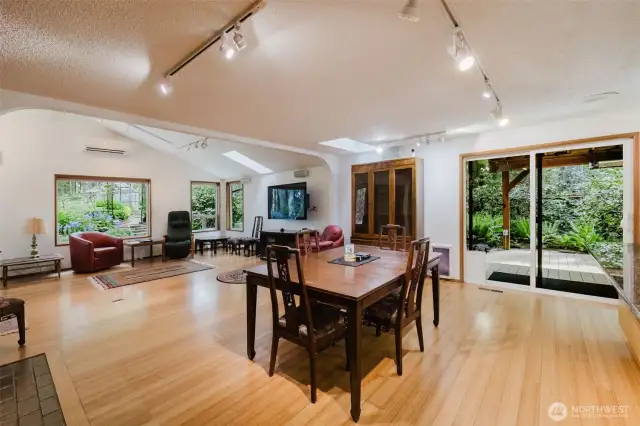 The enormous great room off the kitchen - where soaring ceilings and abundant natural light create a light & bright ambiance.