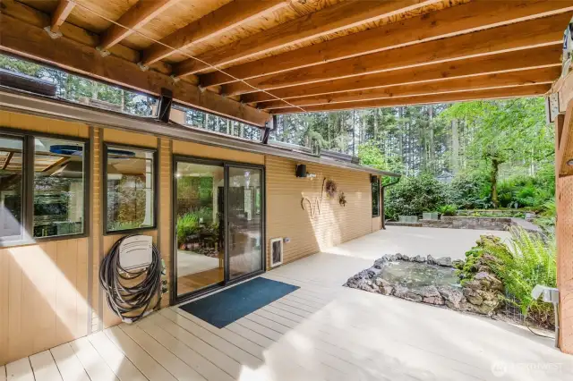 The heated, covered outdoor patio offers a peaceful retreat, with the gentle sound of a cascading waterfall - ideal for unwinding after a long day!