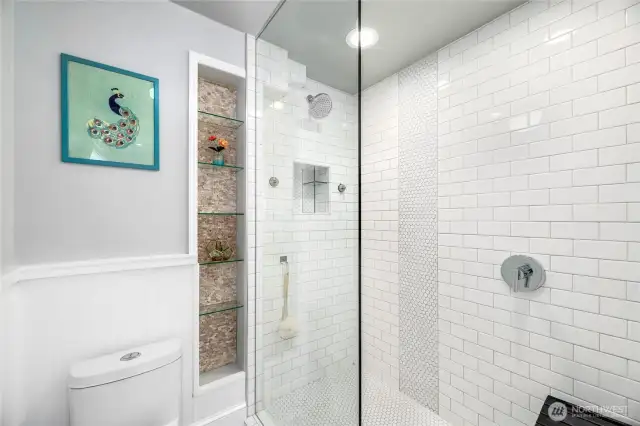 The luxurious Primary Bathroom has a Walk-in Shower with tiled up to the ceiling and built in shelves, and pocket door for privacy. The rest of the bathroom features a  Double Sink Vanity with storage and a completely seperate built-in vanity area area.
