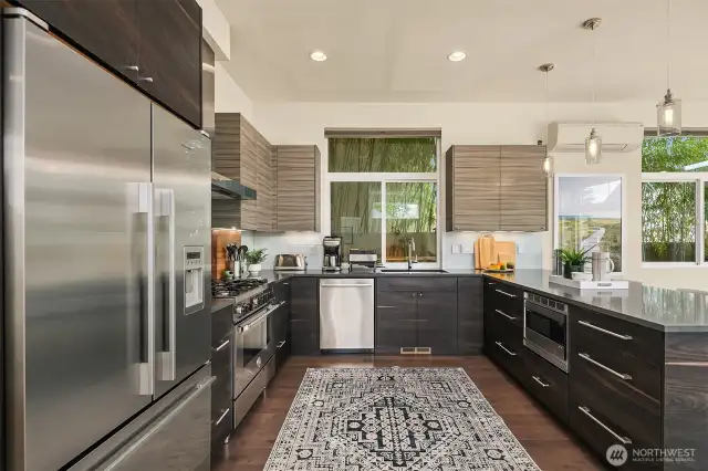 Stainless steel appliances set in custom cabinetry finished with Quartz countertops.