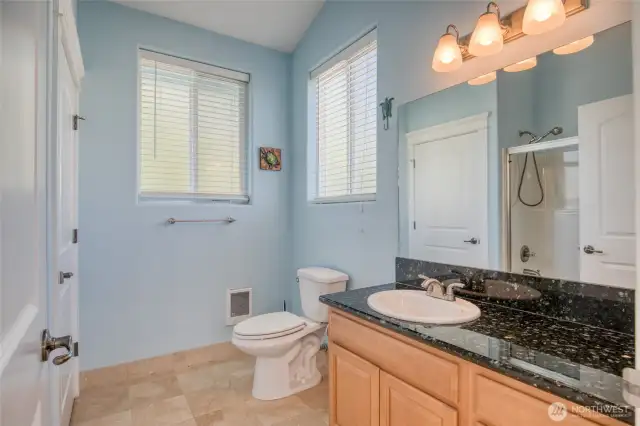 Bathroom has granite countertops that match the kitchen.