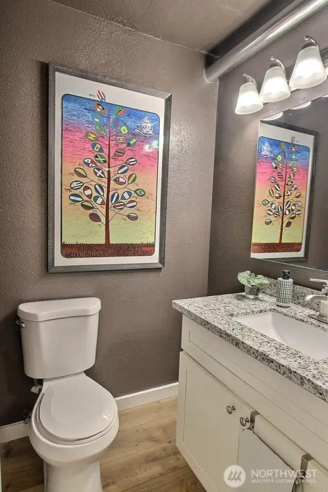 Stylish bathroom featuring a sleek granite countertop and a modern, updated backlit mirror that adds both function and flair.
