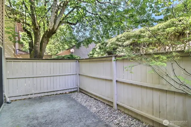 Fully fenced second patio, right off the dining room, is surrounded by mature landscaping that provides privacy and natural shade, keeping the space cool and inviting.