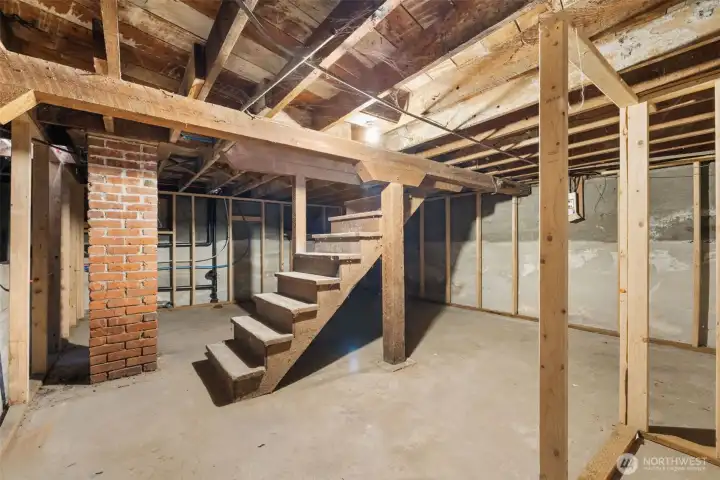 Lower level with laundry plumbing roughed in, framing in place, and walls sealed—ready for your finishing touches.