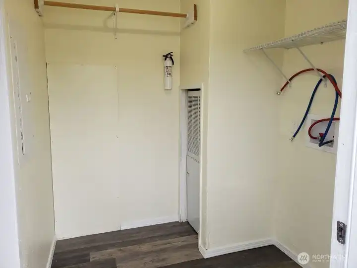 Separate Utility Room has Newer Interior Paint, Trim, Vinyl Plank Flooring, Shelf and Hanging Rod.