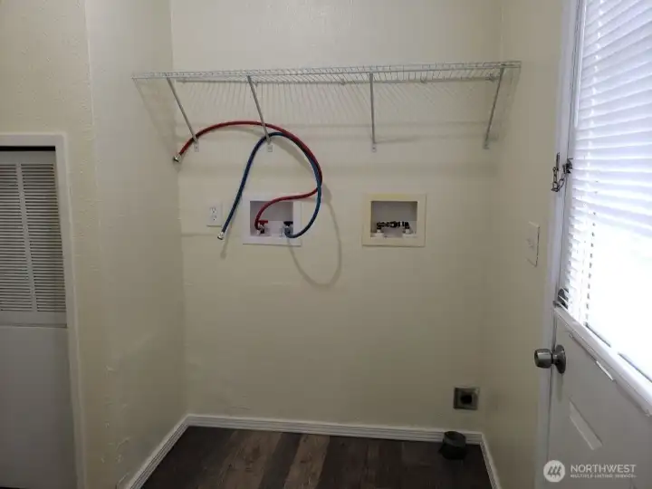 Another Picture of the Separate Utility Room has Newer Interior Paint, Trim, Vinyl Plank Flooring, Shelf Back Door.