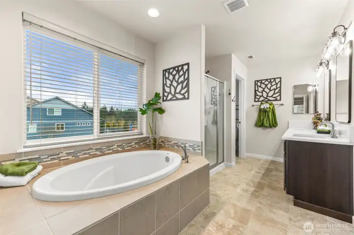 Spacious primary bath with soaking tub and large window