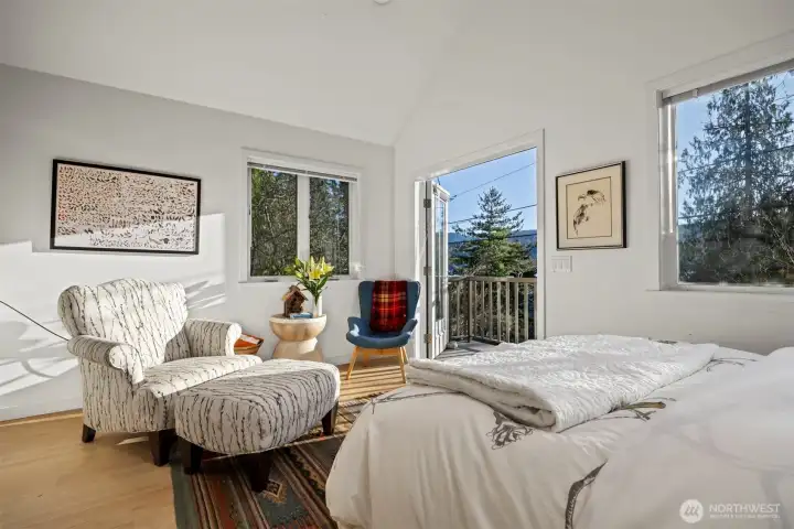 Looking from the sleeping area toward the sitting area with the deck and lake views beyond.