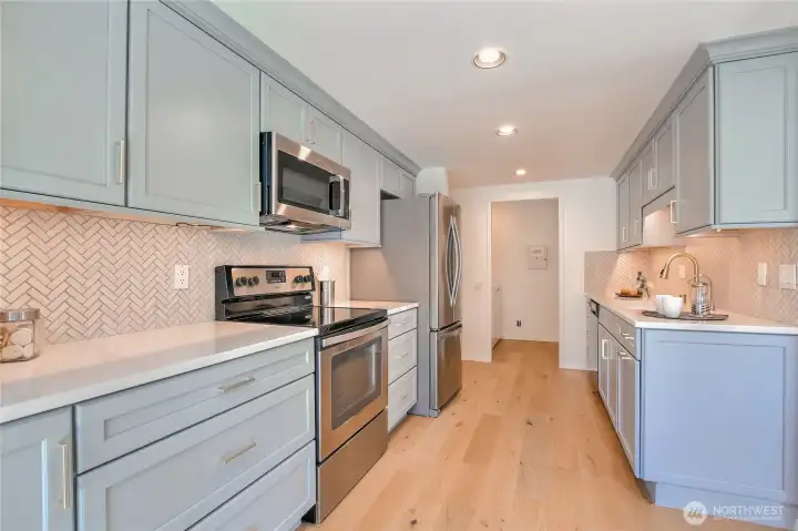 Granite counters, new cabinets, soft close drawers, pull-outs, pantry space, S/S appliances & tasteful color scheme.