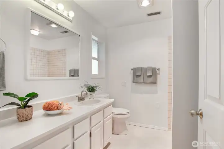 Primary full bathroom with newly painted cabinets.