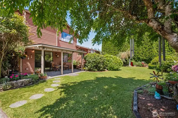Step into your own private garden retreat, where lush lawns, mature trees, colorful flower beds, and thoughtfully curated landscaping create a peaceful park-like setting.