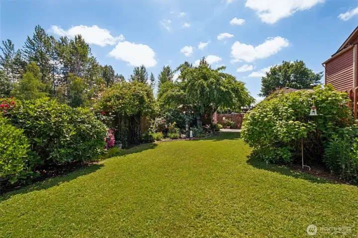 Ample open space and mature bushes & trees make this backyard an ideal sanctuary for entertaining, gardening, or simply unwinding outdoors.