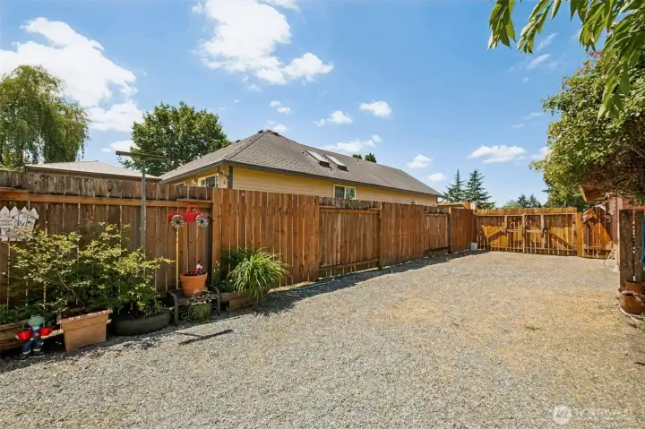 A valuable bonus feature, this fully fenced gravel parking area sits behind double gates and offers ample space for RVs, trailers, boats, or extra vehicles. Equipped with an RV electrical outlet and easy access, it's the perfect setup for storing recreational toys, tackling projects, or simply enjoying additional off-street parking and flexibility.