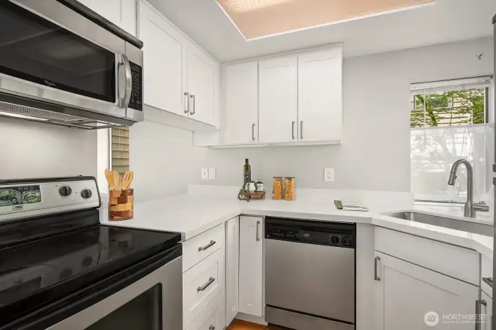 Stainless steel appliances and a corner sink with a nice view of the greenery.