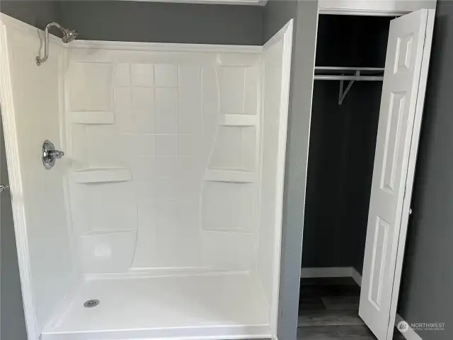 Another view of walk in shower and linen closet.