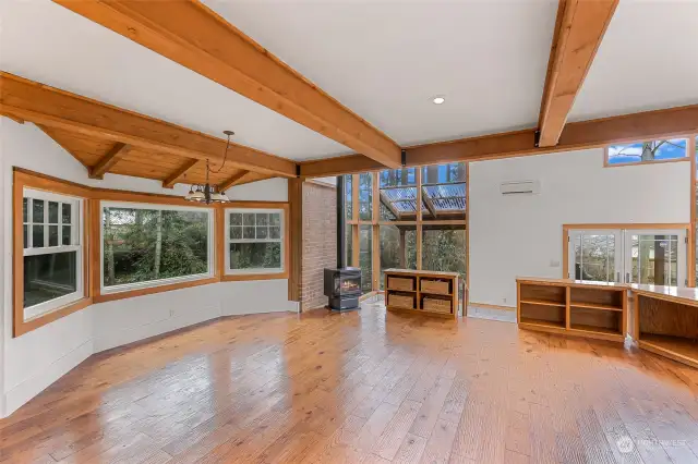 This close-up highlights the character of the fireplace, surrounded by built-in bookcases for both style and functionality. The circular staircase gracefully ascends under the high, airy ceilings.