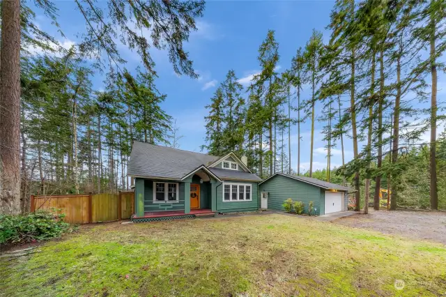 Step closer to a lifestyle of comfort and connection as this farmhouse’s inviting front porch welcomes you home. The timeless green exterior, paired with a warm wooden door and surrounded by towering trees, evokes the perfect blend of relaxation and connection to nature, offering an ideal setting for quiet evenings or friendly gatherings.