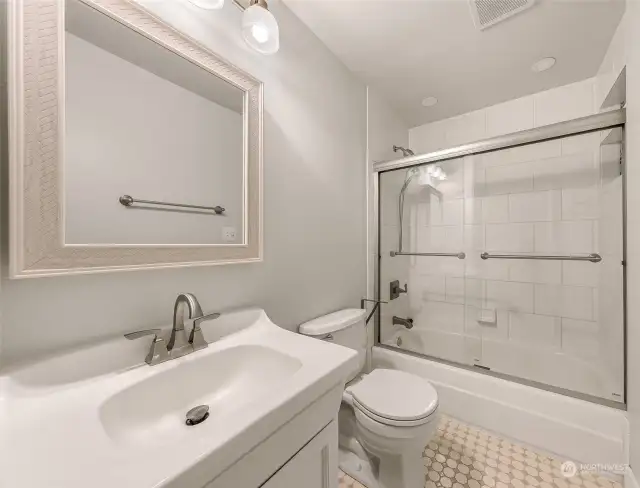 The modernized bathroom features heated floors and tasteful finishes, blending luxury with farmhouse charm. A bright and inviting space for comfort and relaxation.