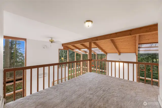 Cozy loft with warm wood paneling and views of the living space below.