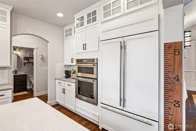 Top-of-the-line appliances include a Subzero refrigerator and combo microwave and wall oven. Glass front cabinets and arched doorways add to the overall elegance of this gracious space.