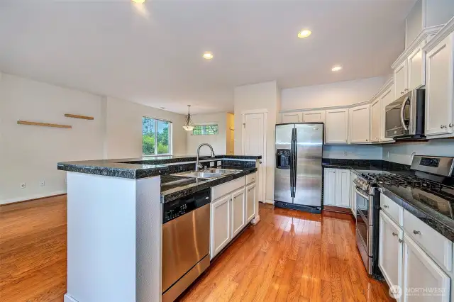 Kitchen with stainless appliances, double sinks, built in microwave, refrigerator with ice maker and water, newer gas cook top, granite counters, two pantries and plenty of cabinets.