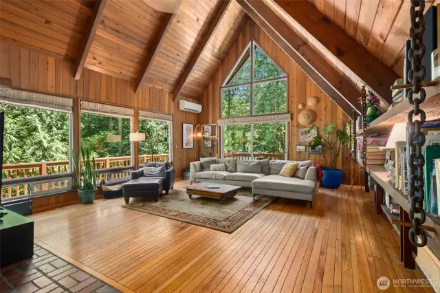 The heart of the home is the spacious living room, anchored by a floor-to-ceiling wood-burning fireplace and flanked by built-in bookshelves—an inviting spot for quiet evenings or lively gatherings.
